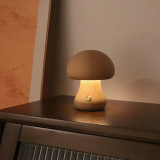 Lampe à poser bois en forme de champignon à LED posée sur un meuble marron avec un tableau à gauche