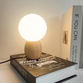 Lampe à poser bois style minimaliste à LED posée sur un livre  avec deux livres à droite