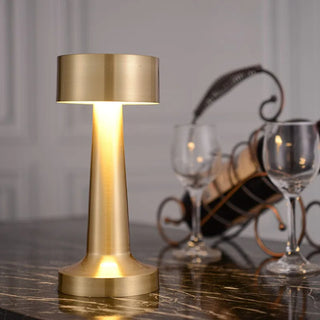 Lampe à poser tactile à LED style moderne posée sur une table avec deux verres et une bouteille de vin posée sur un support